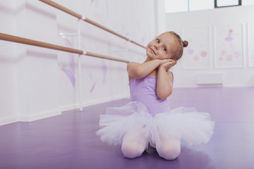 Cute little ballerina dancing at ballet school, copy space. Adorable little girl in ballet outfit...