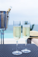 Two glasses of sparkling wine near infinity swimming pool