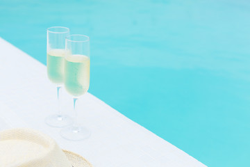 Two glasses of sparkling wine near infinity swimming pool