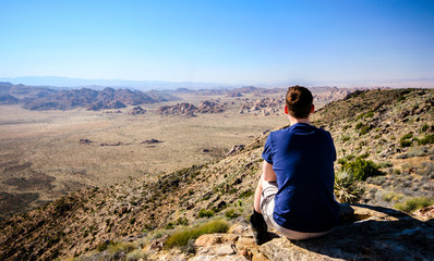 Naklejka premium Hiker in joshua tree np enyoing the view into the valley
