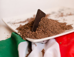 Plate with grated chocolate posed on italian flag