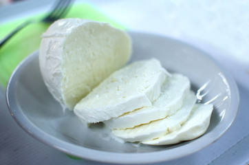 Cut of mozzarella on the white plate