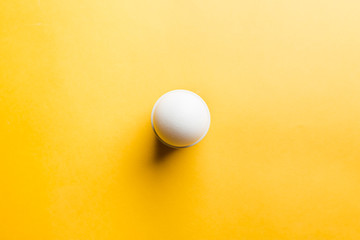 White egg on the yellow background in center. Pop art design minimalism style