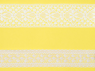 White lace on yellow background. Lacework concept
