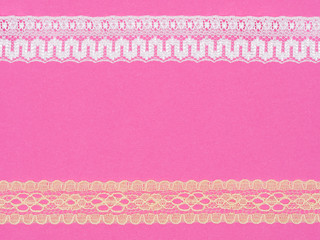 White and beige lace on pink background