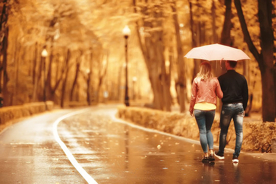 Two People Under An Umbrella / A Man And A Woman Are Walking In A Park With An Umbrella, Walking In The Fall In The Rain, An Autumn Umbrella