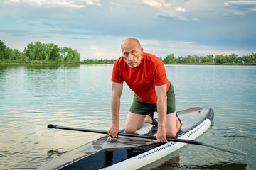 senior paddler with his stand up paddleboard