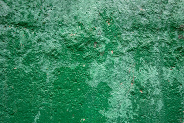 old shabby green concrete wall with deep relief and damage. rough surface texture