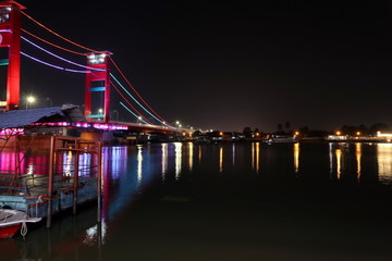 Fototapeta na wymiar Palembang's Ampera bridge is photographed at night, with natural lighting and slow speed photography techniques.