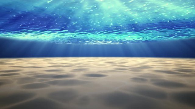 Beautiful underwater sea scene view  with sun light beams shining from above coming through the deep clear blue water causing a beautiful ocean waves ripple and white sand underwater.Seamless loop.