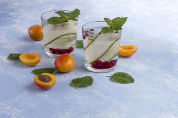 Fresh cool detox drink with cucumber, berries and peaches or aprikotes.