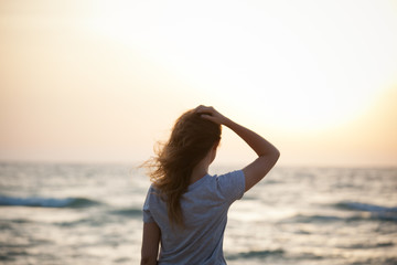 Fototapeta na wymiar beautiful girl at sunset on the sea
