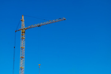 Tower crane over clear blue sky. Space for text