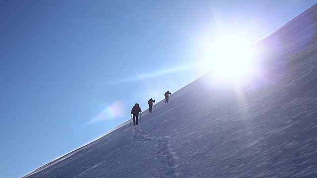 group of climbers moving up by snowy mountain slope. ascent on the Kazbek mount at sunny windy day. Climbing and mountaineering concept. Full HD stock footage. mountain Alps climbing mountaineering