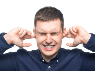 Man holding hands to ears. Portrait of man holding hands to ears covering to shut out noise over white background