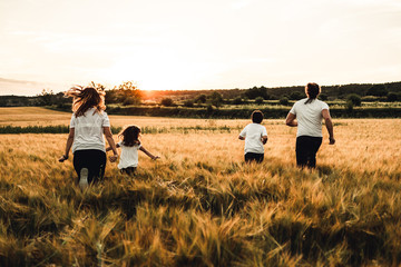 Happy family running through the countryside. Family having fun field