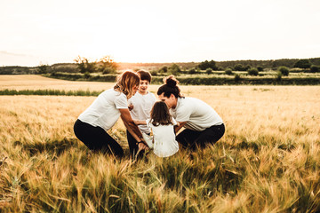 Happy family having fun in the field. Concept of a joyful and united family