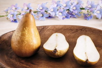 closeup ripe pears on a wooden vintage plate on the table, sweet fruit dessert, autumn harvest, diet products, place for text