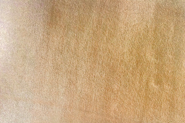 Texture of fabric with metallized gold plating. Golden background. Shiny surface. Close-up.