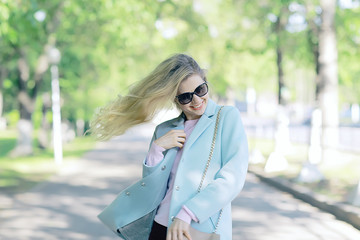 portrait of a european beautiful female model wearing sunglasses / girl outdoors walking, happy cheerful girl wearing glasses