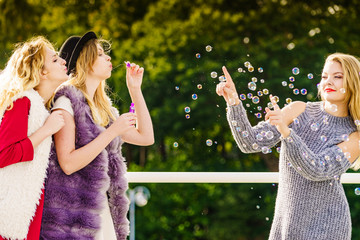 Obraz premium Women blowing soap bubbles, having fun