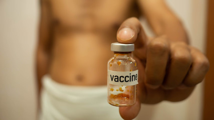 OLYMPUS DIGITAL CAMan put a white towel holding bottles of vaccines and injection needle. Concept Prevent  infection by vaccination before getting infected.MERA