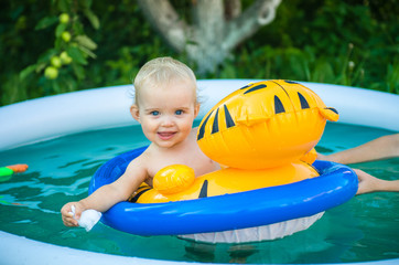 the child is swimming in an inflatable pool