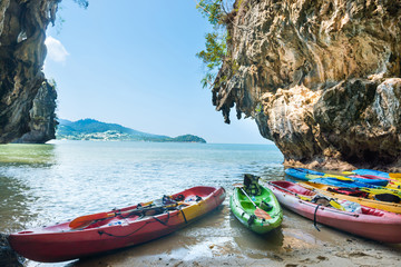 Fototapeta na wymiar Colorful kayaks moored at sand beach at blue sea water near tropical islands