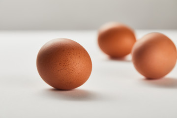selective focus of chicken eggs on white surface
