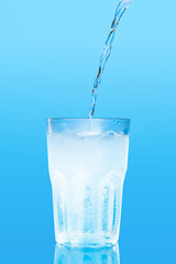 Close up pouring purified fresh drink water from the bottle on table
