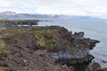 Hiking trail from Anarstapi to Hellnar with the raw ocean und big rocks and mountains in the west of Iceland at Snaefellsnes Peninsula