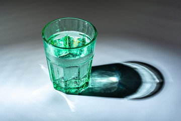 glass of water on a table  on a dark background