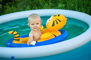 the child is swimming in an inflatable pool