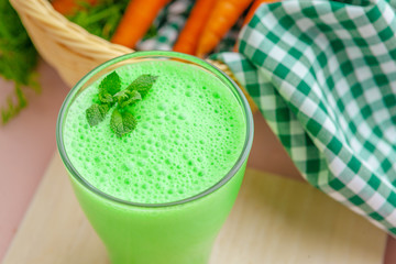 Green smoothie in glass over rustic wooden background