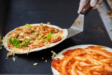 Hands cook making healthy fresh fajitas or fajitos with cheese, beef, tomatoes. Served very hot, from grill. Concept of national food