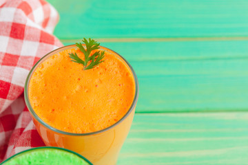 Glasses of carrot juice with vegetables on table close up