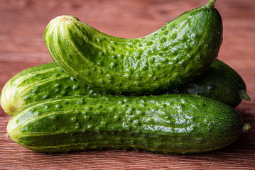 Three fresh cucumbers are on the table. Close-up. Selective focus.