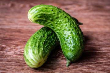 Two fresh cucumbers are on the table. Close-up. Selective focus.