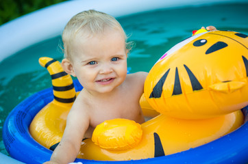 the child is swimming in an inflatable pool