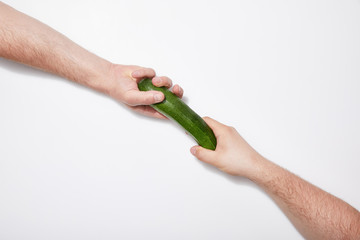 cropped view of men sharing green zucchini on white background