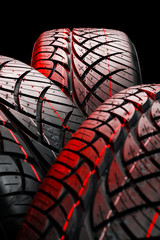 Row of car tires with a profile close-up on a black background