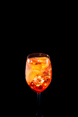 Stylish alcoholic aperol spritz trendy cocktail with orange slice on black background. Place for your text. Vertical photo.