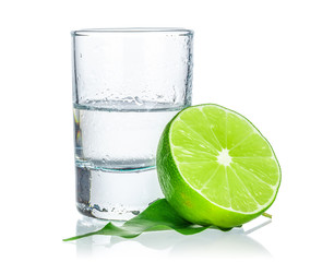 Shot of tequila with a slice of lime no white background