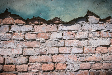 Rough red brick block with frame of green cement 