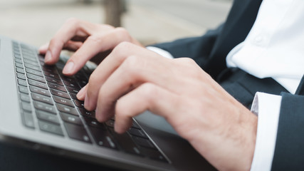 Fototapeta na wymiar Close-up of businessman's hand typing on laptop