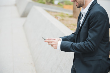 Smiling portrait of a young businessman using smartphone