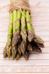 Bunch of fresh asparagus on wooden table.