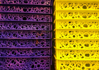 Plastic laundry baskets close-up, yellow and purple, texture for background.