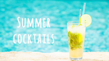 Mojito cocktail at the edge of an outdoor resort pool. Concept of luxury vacation. Horizontal, wide screen format. Summer cocktails wording