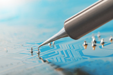 Soldering of electronic circuit board with electronic components. Soldering station. Engineers...